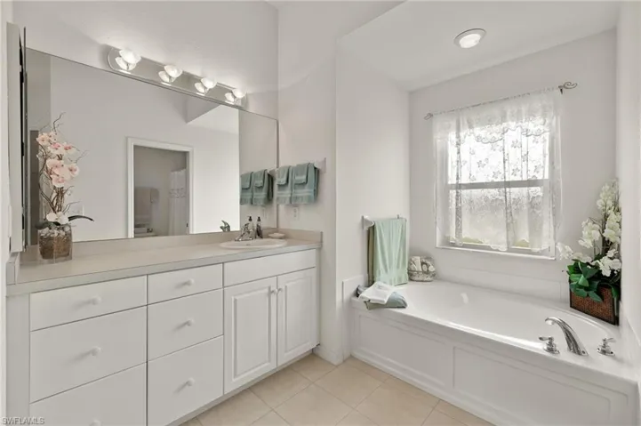 Bathroom with vanity, a tub, and tile patterned floors