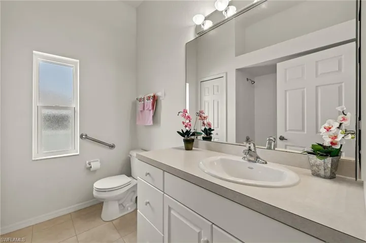 Bathroom with vanity, toilet, and tile patterned flooring