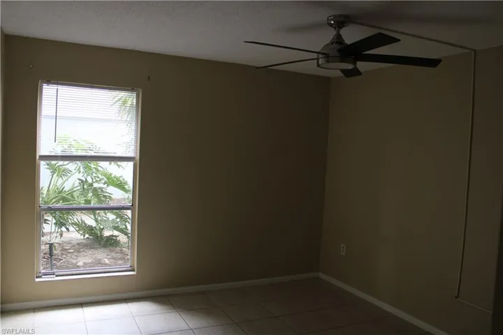 Tiled spare room featuring ceiling fan and a textured ceiling