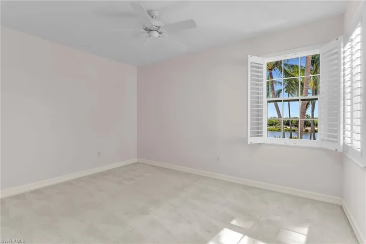 Second bedroom with light colored carpet and a ceiling fan.