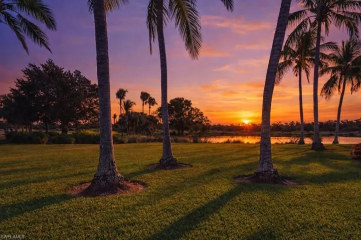 At dusk, scenic water views just outside the unit are framed by manicured lawns and tropical surroundings.