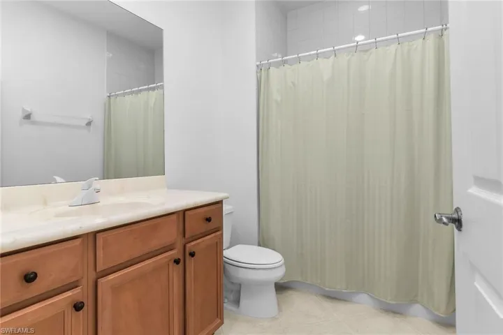 Full bath featuring vanity and light tile patterned floors.