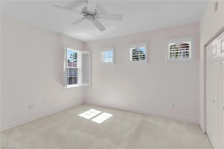 Third bedroom with light carpet, a closet, and ceiling fan.