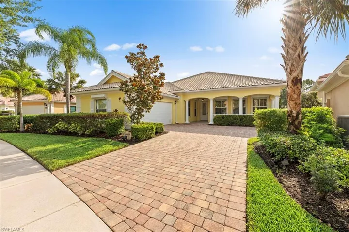 Mediterranean / spanish-style home featuring stucco siding, a front lawn, a tile roof, a garage, and driveway