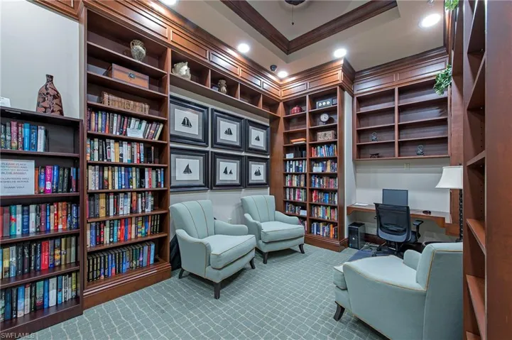 Carpeted office space featuring recessed lighting, ornamental molding, and wall of books