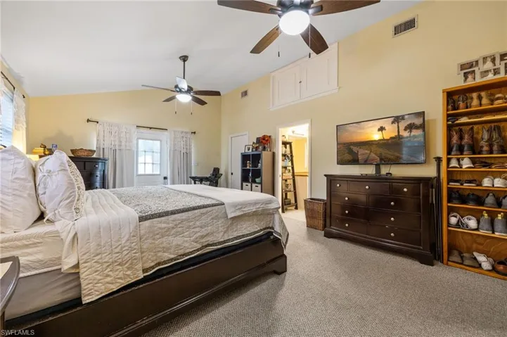 Bedroom featuring carpet, ceiling fan, and high vaulted ceiling
