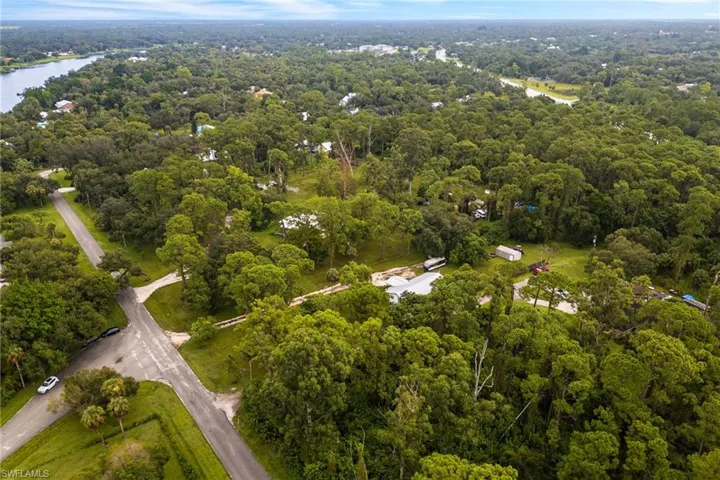View of property location with a forest and a nearby body of water