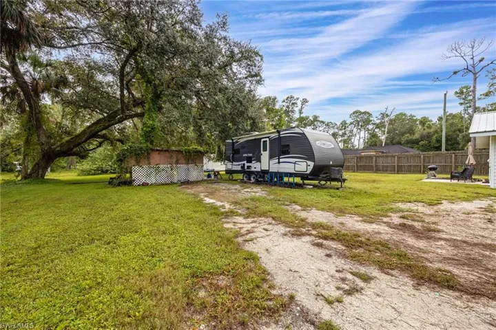 View of green lawn with view of wooded area
