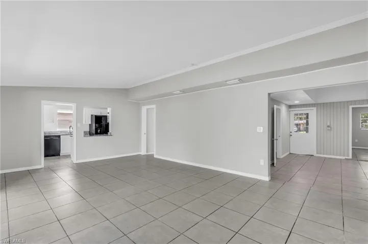 Unfurnished living room featuring vaulted ceiling and light tile patterned floors