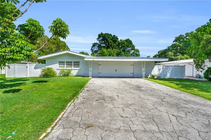 Ranch-style house featuring a front yard and a garage