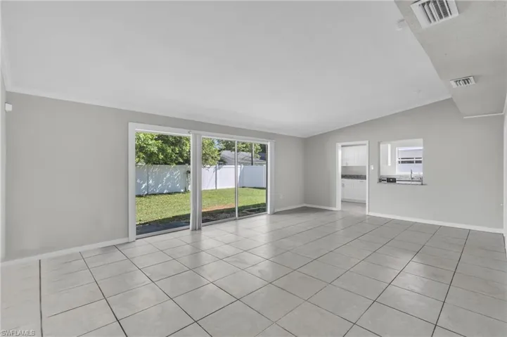 Tiled spare room with ornamental molding, sink, plenty of natural light, and vaulted ceiling