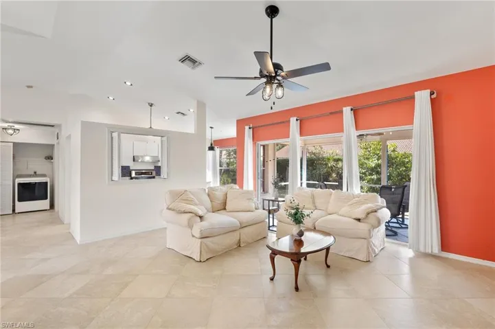 Tiled living room featuring plenty of natural light, ceiling fan, and washer / clothes dryer