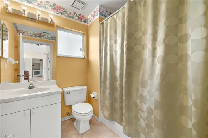 Bathroom with tile flooring, oversized vanity, and toilet