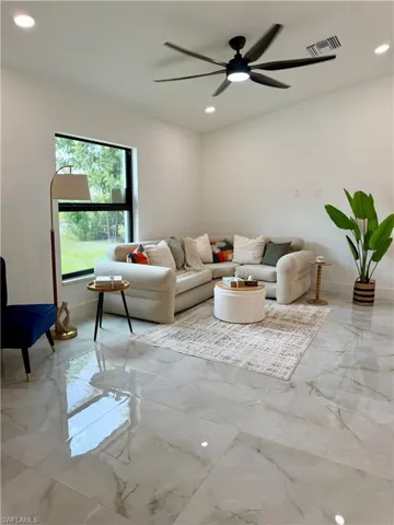 Spacious room featuring large format polished tile flooring, recessed lighting, and a modern ceiling fan