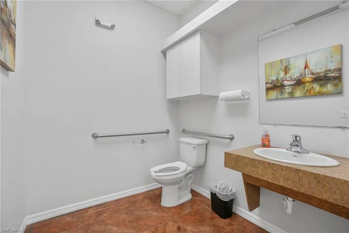 Bathroom with toilet and dark tile patterned floors