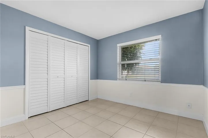 Unfurnished bedroom with a closet and light tile patterned flooring