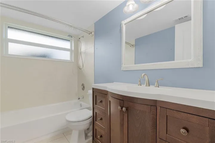 Bathroom featuring vanity, tub / shower combination, and light tile patterned floors