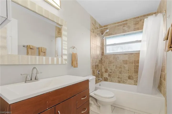 Bathroom featuring shower / bath combo, vanity, and light tile patterned floors