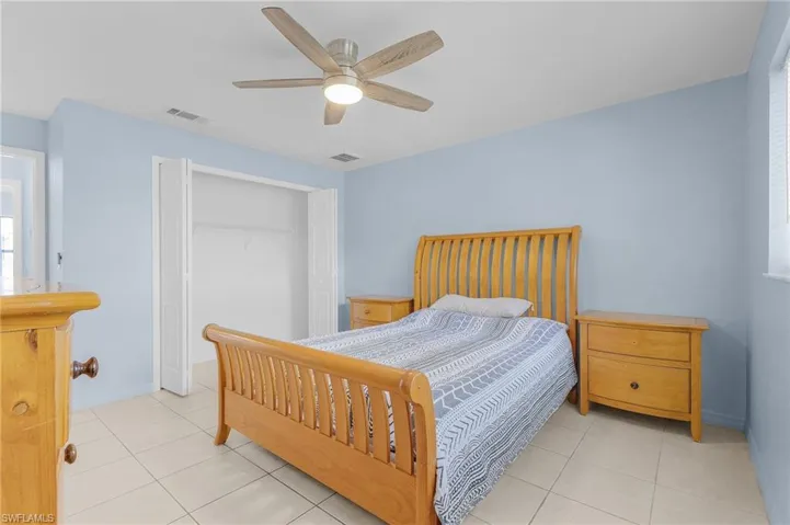 Bedroom with a closet, a ceiling fan, and light tile patterned floors