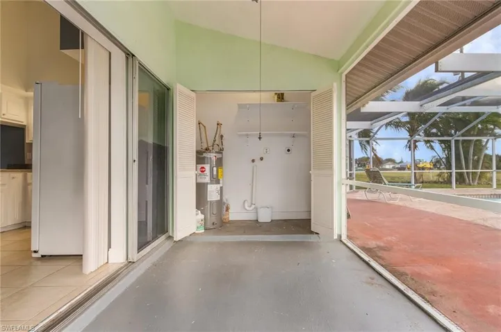 View of patio with a lanai, a sunroom, and electric water heater