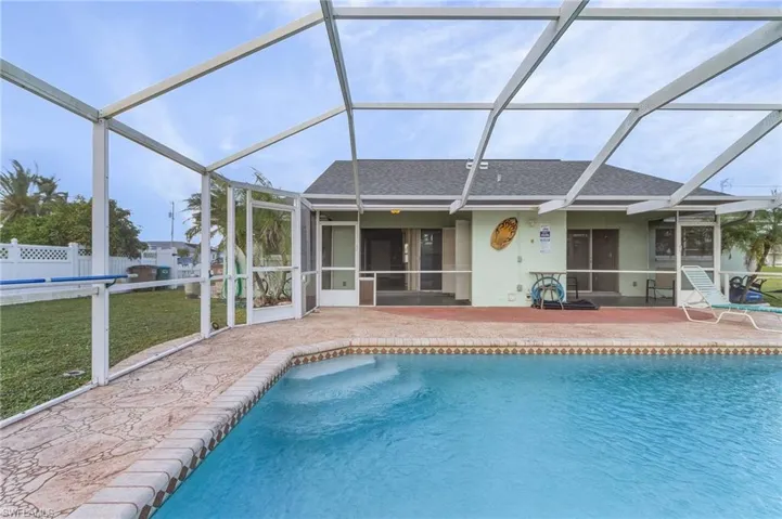 Outdoor pool featuring a sunroom, a lanai, and a patio area