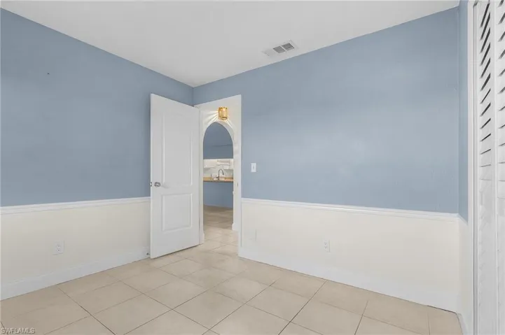 Spare room with arched walkways and tile patterned flooring