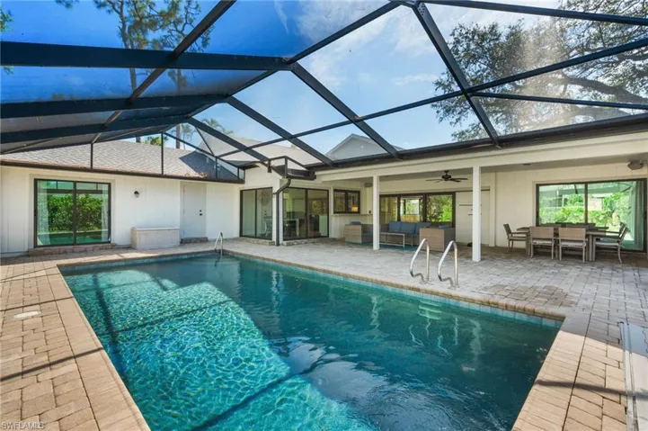 View of swimming pool with an outdoor living space, a patio, ceiling fan, and a lanai