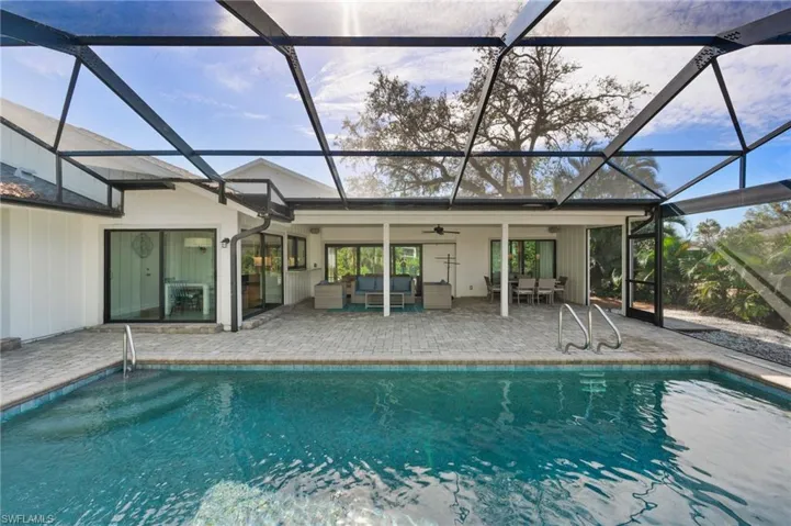 View of swimming pool featuring an outdoor living space, ceiling fan, a lanai, and a patio