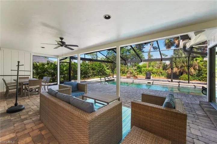 View of patio featuring outdoor lounge area, ceiling fan, and glass enclosure