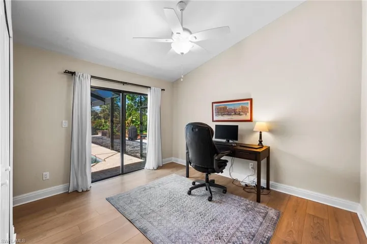 Home office with light wood-type flooring, ceiling fan, and lofted ceiling