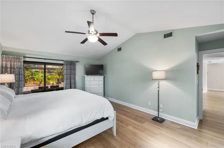 Bedroom featuring access to exterior, ceiling fan, light hardwood / wood-style floors, and lofted ceiling