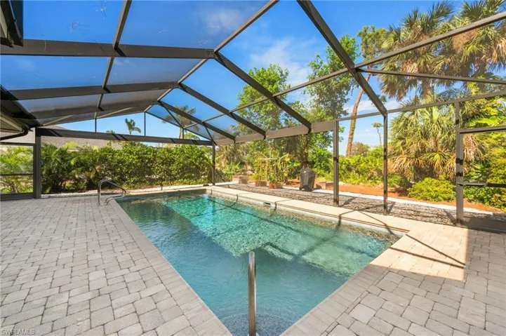 View of pool with a lanai and a patio