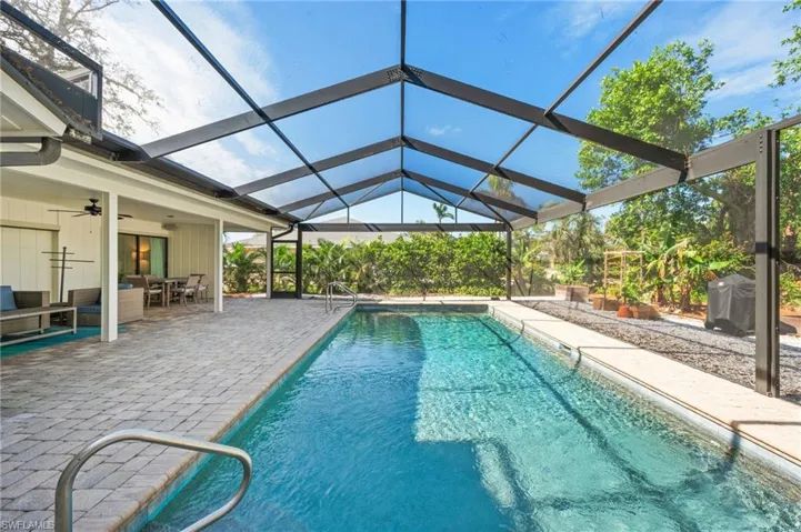 View of pool featuring a lanai, ceiling fan, a patio area, and outdoor lounge area