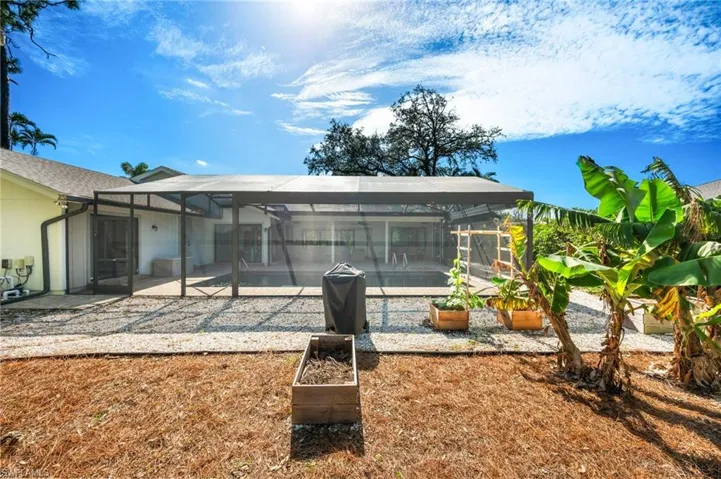 Back of house featuring a lanai, a patio area, and a swimming pool