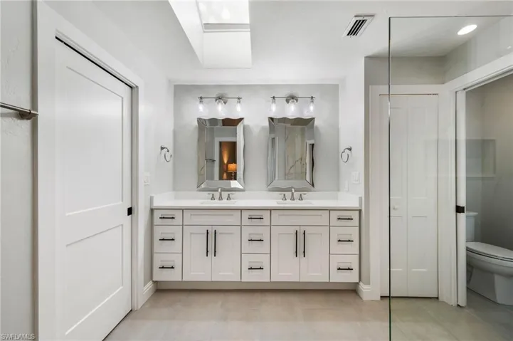 Bathroom featuring a skylight, tile patterned flooring, vanity, and toilet