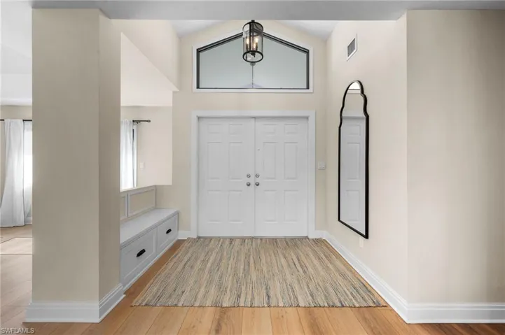 Entrance foyer featuring light hardwood / wood-style flooring and lofted ceiling