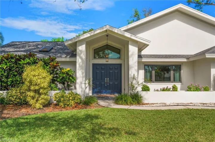 Doorway to property with a lawn