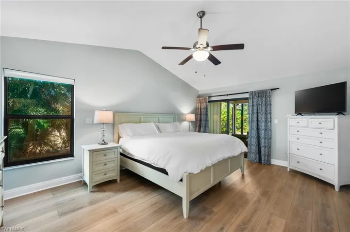 Bedroom featuring ceiling fan, light hardwood / wood-style floors, and vaulted ceiling