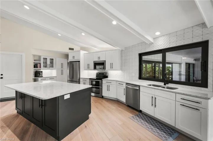 Kitchen featuring white cabinets, stainless steel appliances, light hardwood / wood-style flooring, and sink