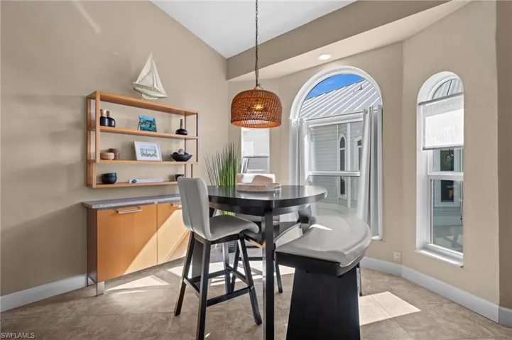 Dining room featuring lofted ceiling, light tile patterned floors, and recessed lighting