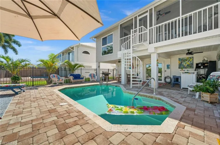View of swimming pool with ceiling fan, a balcony, a patio area, and stairs