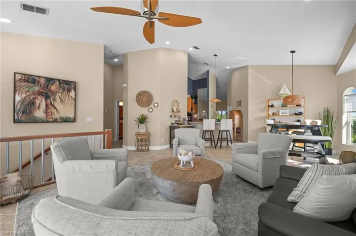 Living room featuring high vaulted ceiling, recessed lighting, a ceiling fan, arched walkways, and tile patterned floors