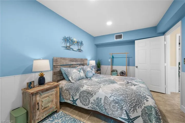 Bedroom featuring tile patterned floors and wainscoting