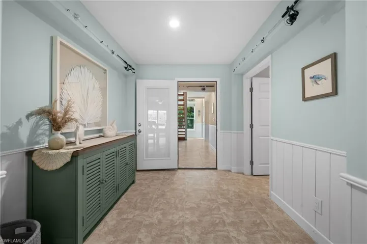 Doorway to outside featuring wainscoting, tile patterned floors, and a barn door