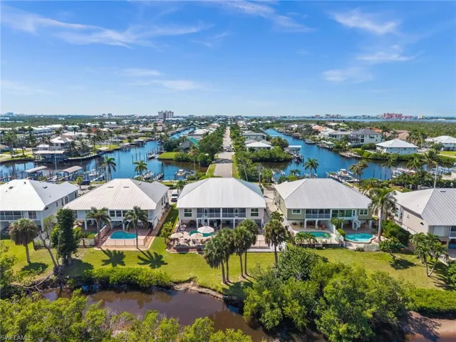 Aerial view of residential area with a nearby body of water and a pool area