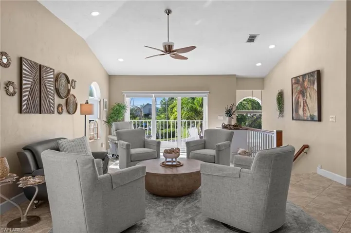 Living area with a ceiling fan, light tile patterned floors, recessed lighting, and vaulted ceiling