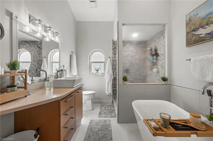 Full bath with a soaking tub, vanity, a shower stall, and light tile patterned flooring