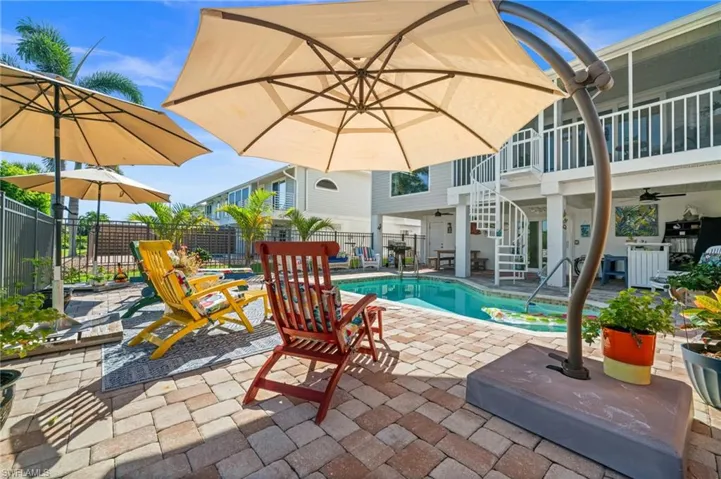 View of swimming pool with a patio area, ceiling fan, stairs, and a balcony