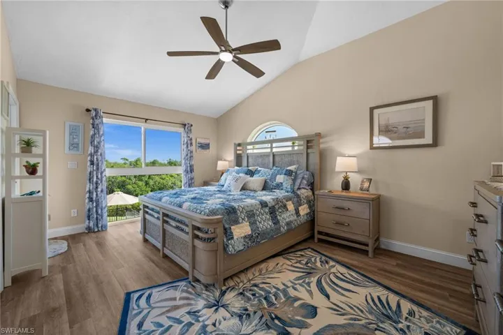 Bedroom with lofted ceiling, dark wood finished floors, and a ceiling fan
