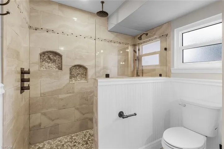 Bathroom with a walk in shower and wainscoting